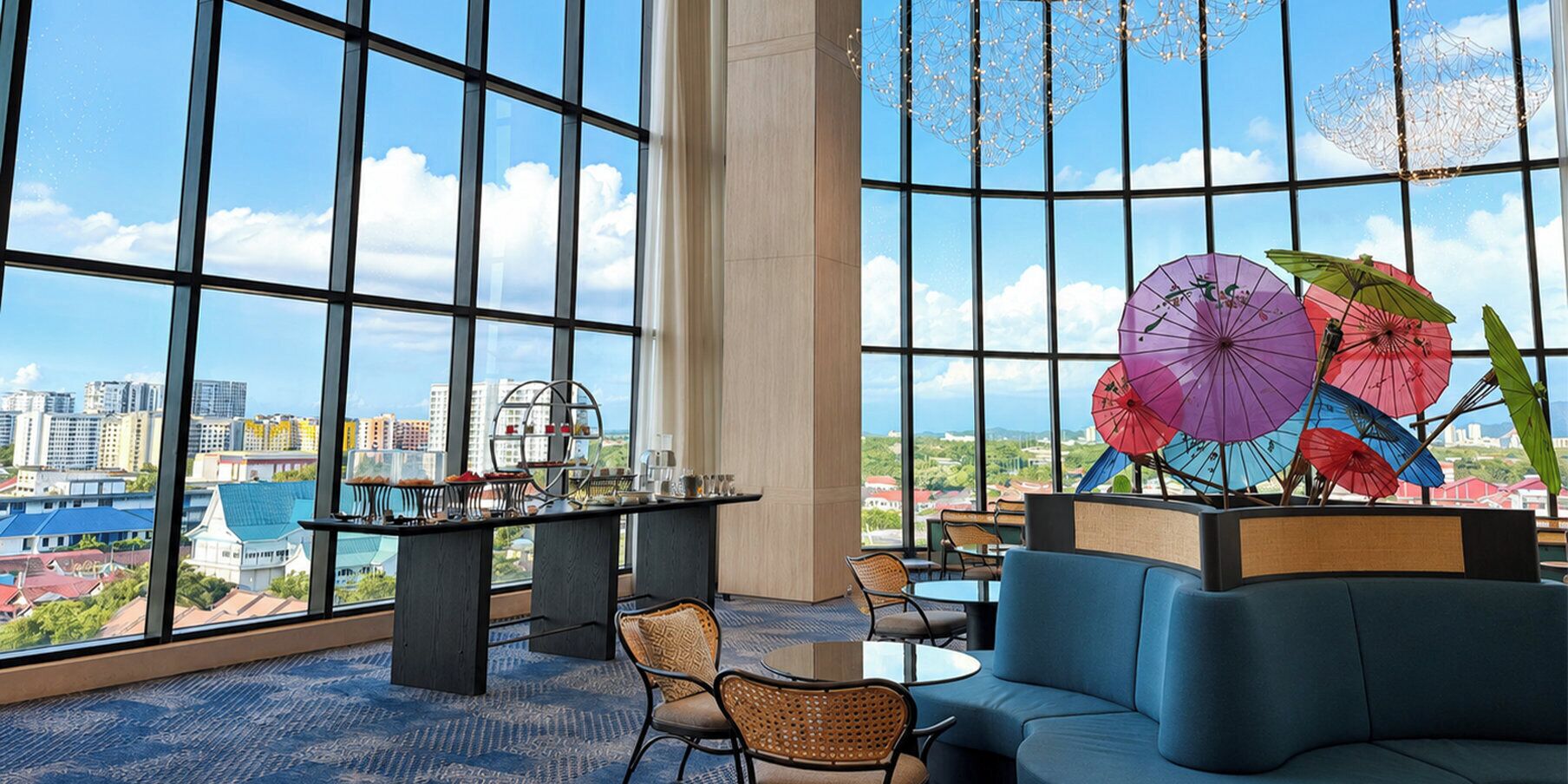 A modern interior with large windows, a seating area, and a table with a view of the cityscape.
