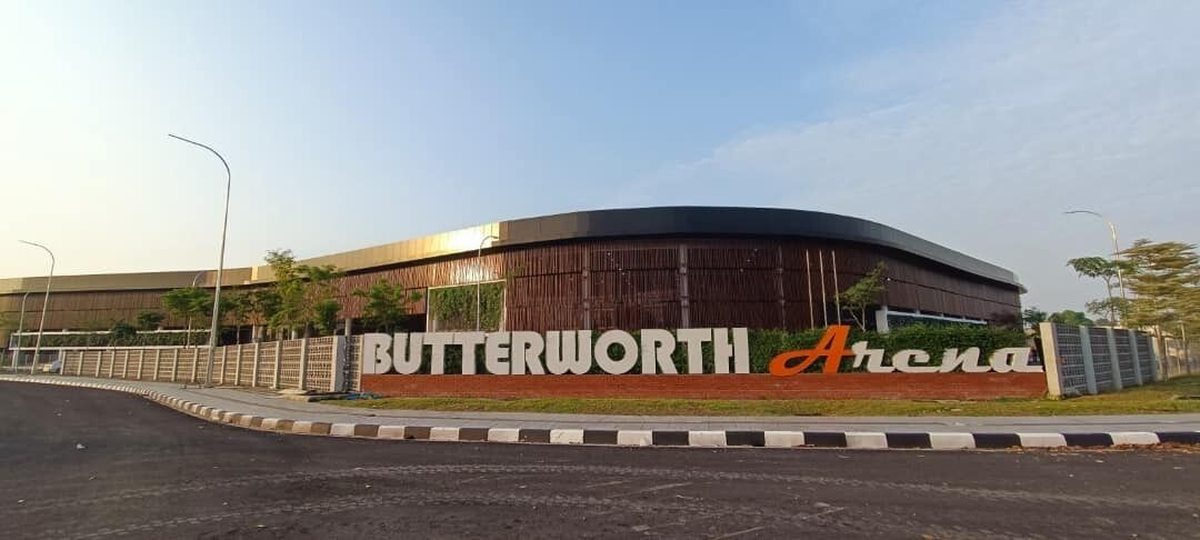 A modern building with a curved facade and a sign that reads "Butterworth Arena".