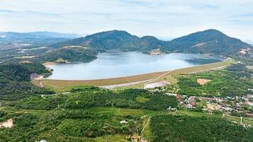 An aerial view of a lake surrounded by hills, with a small town and a dam in the foreground.