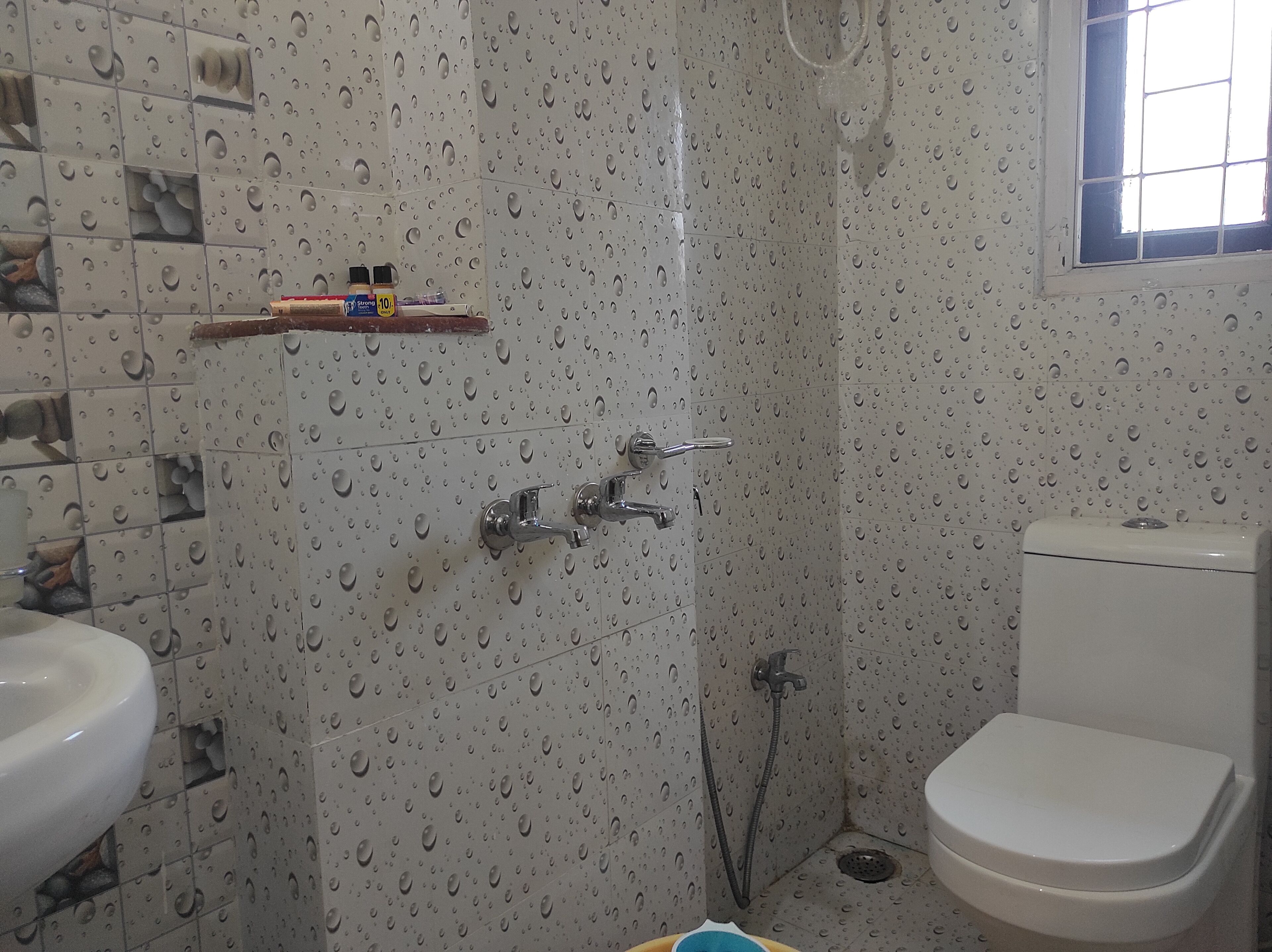 A bathroom with a shower, toilet, and sink.
