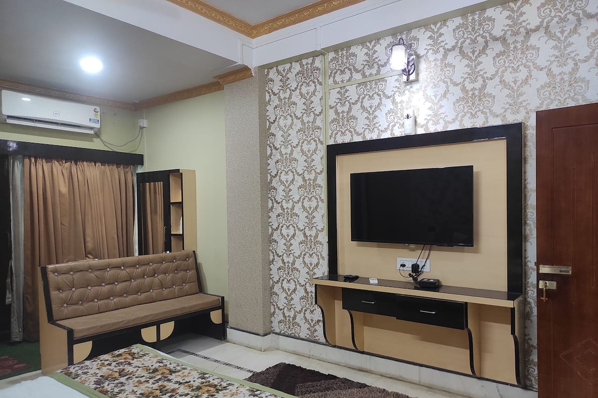 A living room with a sofa, TV, and entertainment unit.