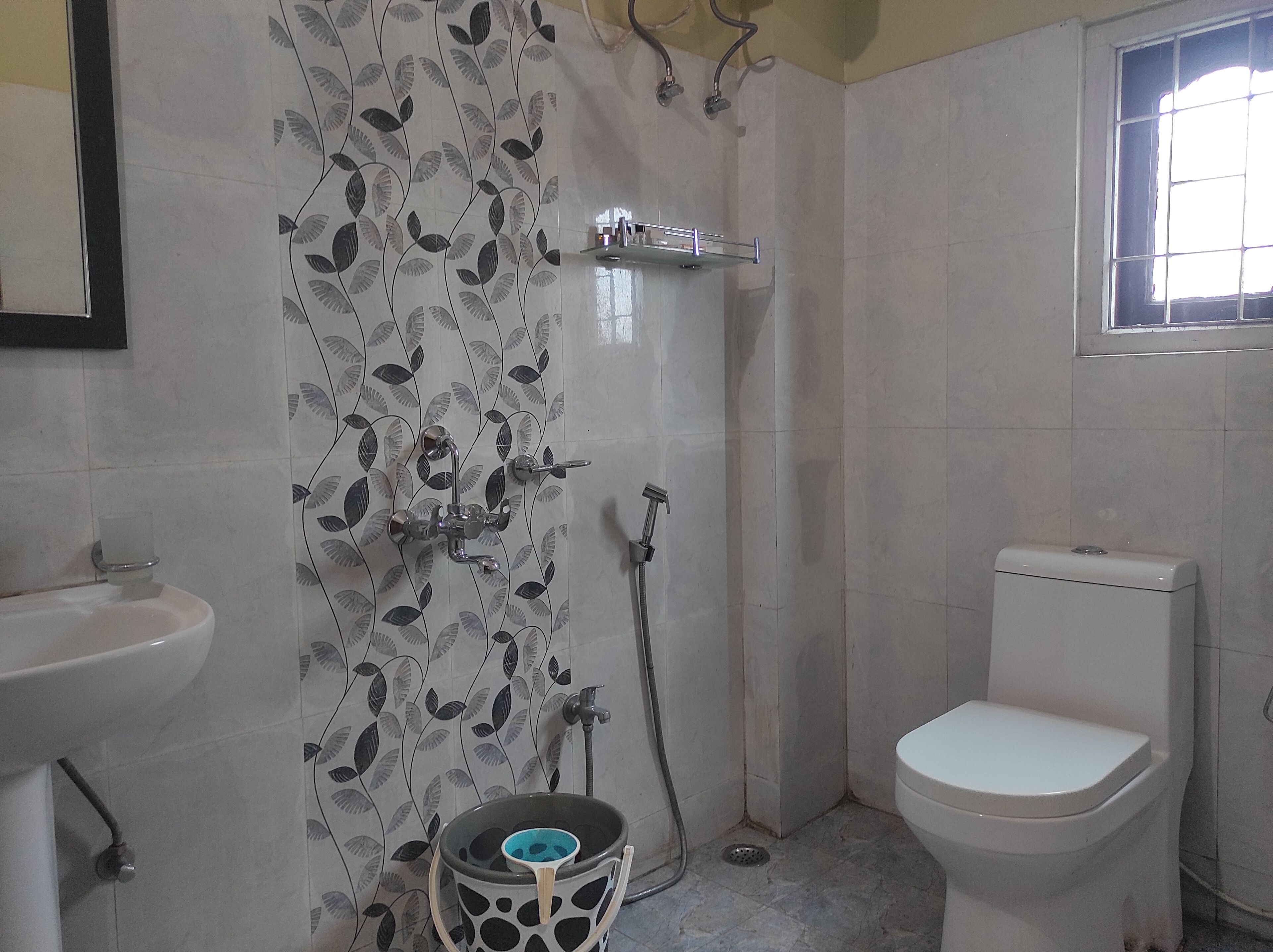 Ein Badezimmer mit Toilette, Waschbecken, Dusche und einem Fenster.