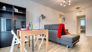 A modern living room with a grey sofa, a wooden dining table, and a bookshelf. - CaseOspitali - Casa Francesca modernissimo trilo (Pioltello)