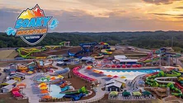 A water park with various slides and pools, surrounded by hills.