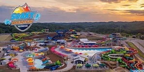 A water park with various slides and pools, surrounded by hills.