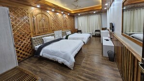 Une chambre d’hôtel moderne équipée de deux lits, d’un bureau, d’une chaise et d’un miroir.