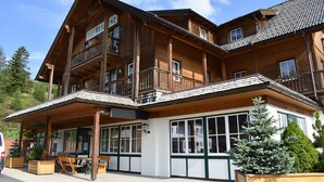 A wooden chalet with a balcony, large windows, and a covered patio area. - Apartment # 14 with balcony (Turrach)