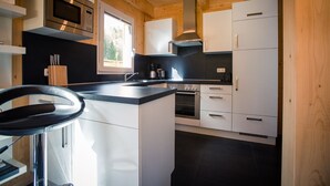 Et moderne køkken med hvide skabe, en sort bordplade og rustfrie stålemmer.