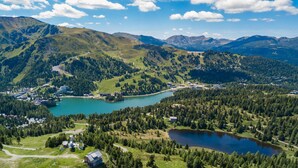 A mountainous landscape with a lake, buildings, and roads. - Chalet #40 with IR-sauna and indoor whirlpool (Turrach)