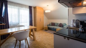 A compact living space with a kitchenette, a dining area, and a sofa. - Studio # 13 with Balcony (Turrach)