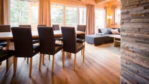 Ein Holzinterieur mit Essbereich, einer Couch und einer Wand aus Stein.