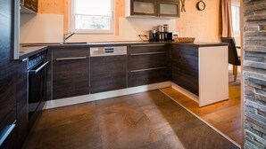 Eine moderne Küche mit dunklen Holzschränken, einem eingebauten Ofen und einem Fenster über der Spüle.