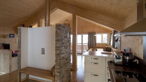 A modern kitchen with wooden beams, stone accents, and a central island.