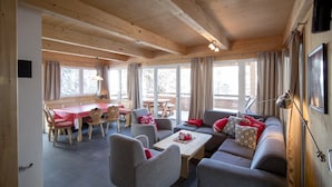 A cozy cabin interior with a dining area, seating, and large windows. - Chalet #30 with IR-sauna and indoor whirlpool (Turrach)