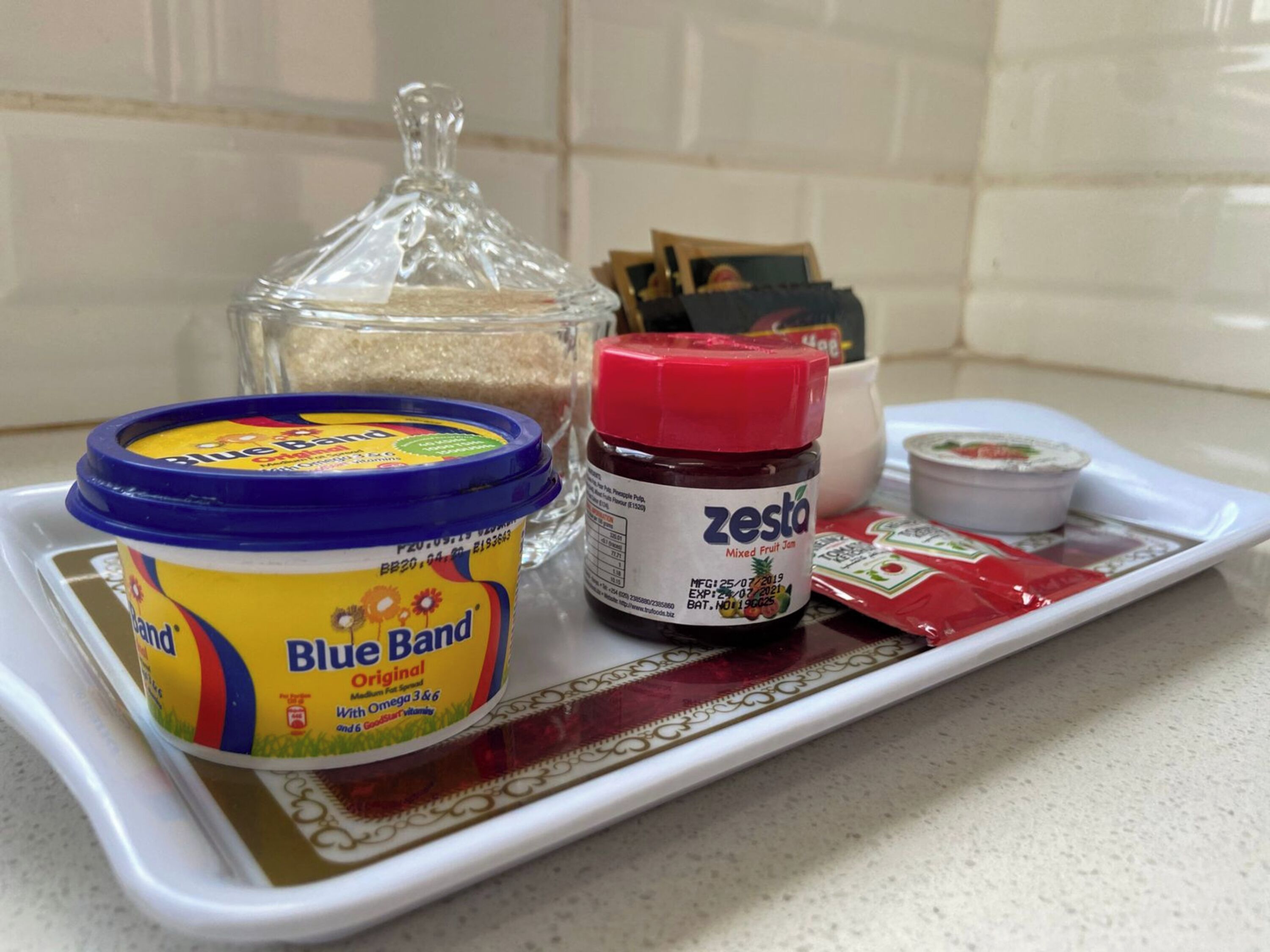 A tray with a container of Blue Band Original yogurt, a jar of Zesta mixed fruit jam, and a small container of yogurt.