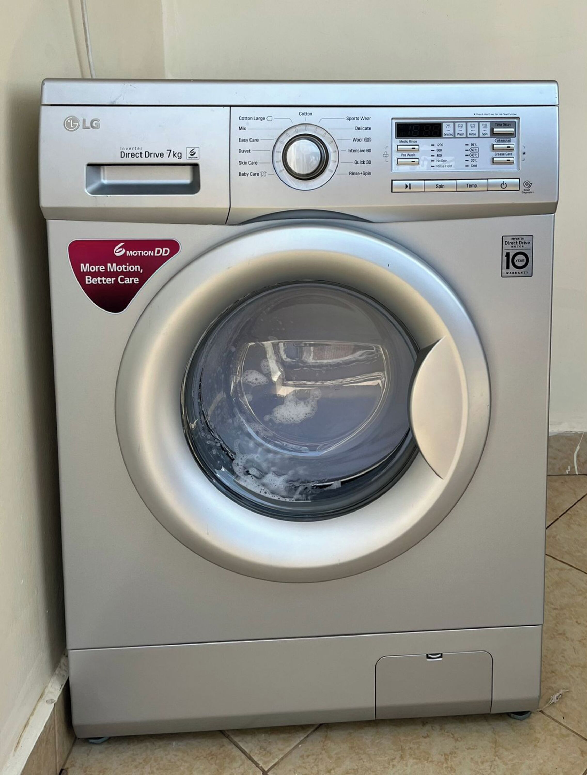 Vista frontal de una lavadora LG Direct Drive de 7kg con tecnología inverter y 10 años de garantía.