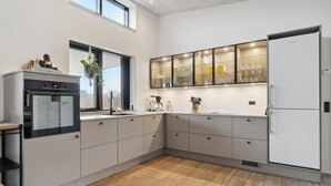 A modern kitchen with a built-in oven, a coffee maker, and a refrigerator. - Gorgeous home in Hadsund with sauna (Hadsund)