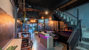 Un interior moderno con mostrador de recepción, zona de estar y escalera.