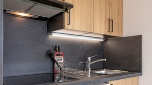 Una cuina moderna amb rentaplats integrat, un vàter d'acer inoxidable i una campana extractora.