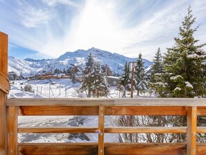 A wooden deck with a view of a snowy mountain landscape, including a prominent peak and a village below. - Renovated studio cabin for 4, south-facing in Avoriaz (Avoriaz)