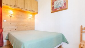 A room with a bed, wooden walls, and a framed picture on the wall. - Cozy 2-room south, 5 pers, Avoriaz (Avoriaz)