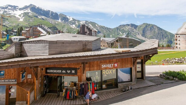 A wooden building with shops named 'Quiksilver' and 'Roxy'.