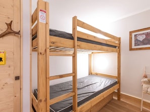 A bunk bed with a wooden frame, a mattress, and a headboard.