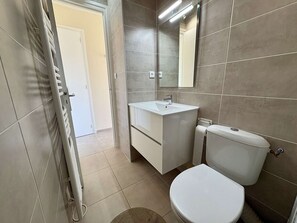 Ein Badezimmer mit Toilette, Waschbecken und Spiegel.