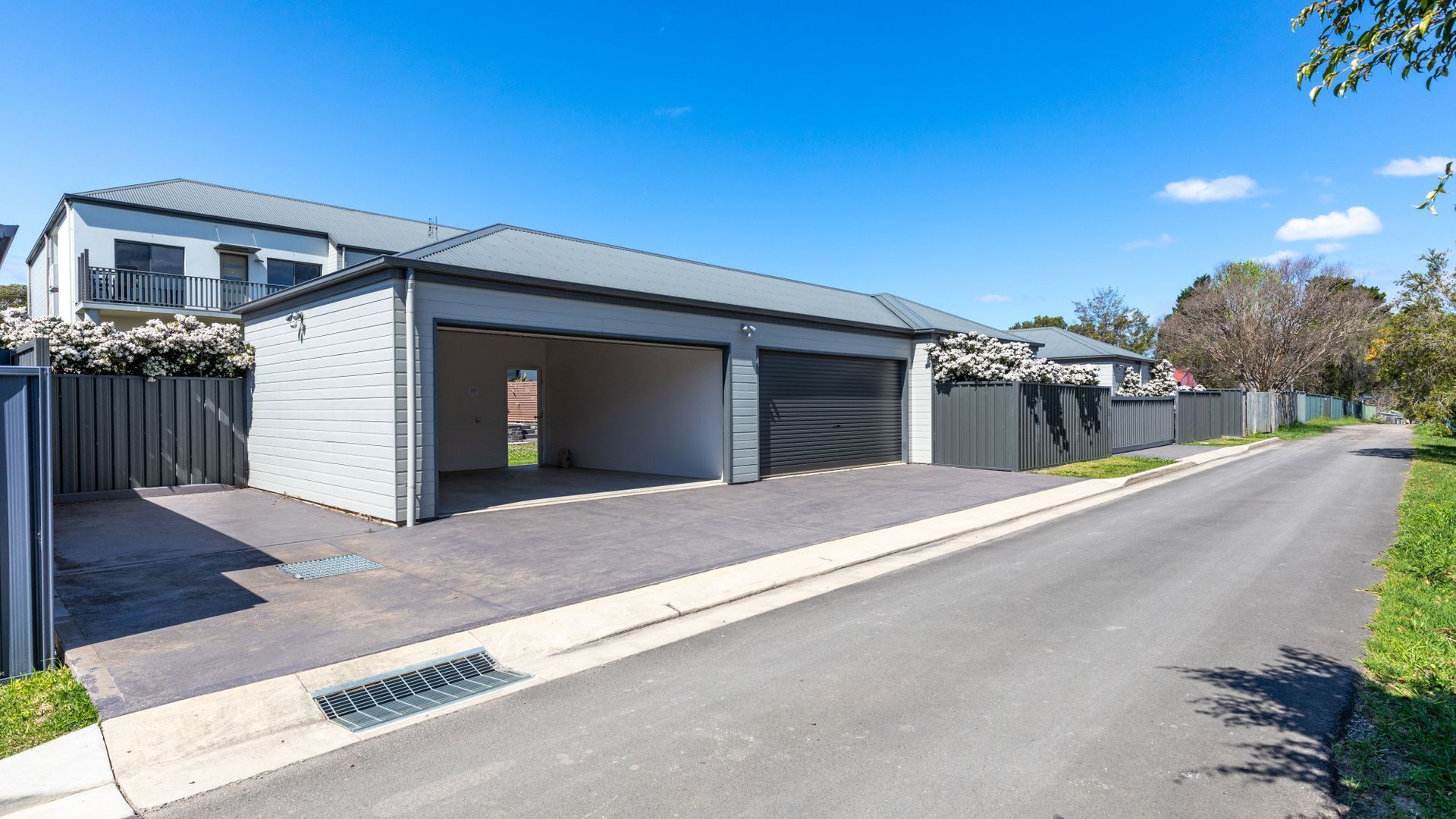 A modern two-story house with a garage, a driveway, and a well-maintained lawn.