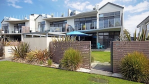 A modern multi-story residential building with a flat roof, large windows, and a well-maintained lawn. - Interlude Apartment by Book Jervis Bay (Huskisson)