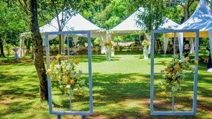 A tented outdoor event area with tables and chairs set up for dining.