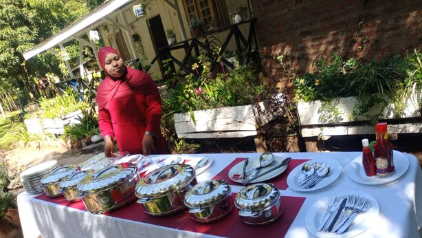 A table set outdoors with multiple food containers and utensils.