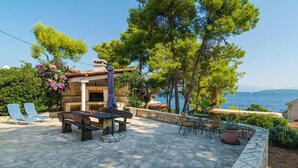 A patio with stone flooring, outdoor furniture, and a stone fireplace. - Awesome home in Stomorska with house sea view (Stomorska)