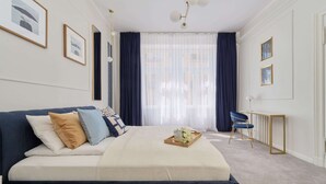 A modern bedroom with a large bed, a desk, and a chair. - Elegant Apartment in Tenement House | Center, 2 Desks for Work (Poznan)