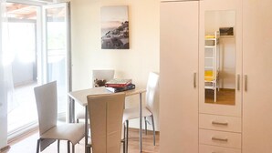 Un coin repas avec une table, des chaises, un ours en peluche et un jeu de société Monopoly.