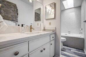 Bathtub, hair dryer, towels, shampoo
