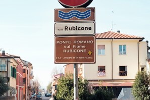 A street sign with 'Rubicone' and 'Ponte Romano sul Fiume Rubicone' text, indicating a location in Italy. - Cozy recently renovated apartment nestled in the historic center (Savignano sul Rubicone)