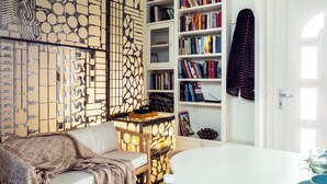 A cozy reading nook with a cushioned chair, a small table, and a bookshelf filled with books. - Cozy recently renovated apartment nestled in the historic center (Savignano sul Rubicone)