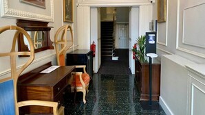 A hallway with a desk and chairs, framed artwork on the walls, a staircase, and a water dispenser. - 2 Bed/2 Bath Large Flat, Ground Floor, Sky TV, AC (Greater London)