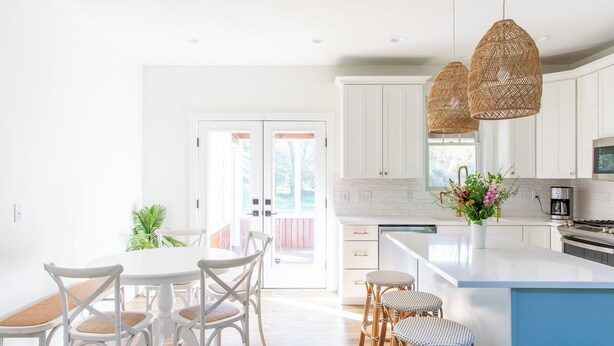 A bright kitchen with white cabinets, a large island, wicker chairs, and hanging pendant lights. - New Pool, Hot Tub, Short Walk To Beach (Union Pier)