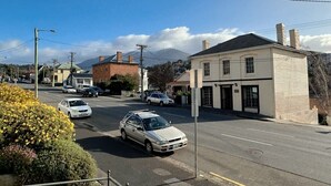 A street view with a building, cars, and a clear sky.