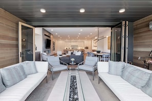 Een moderne woonkamer met een bank, stoelen en een salontafel.