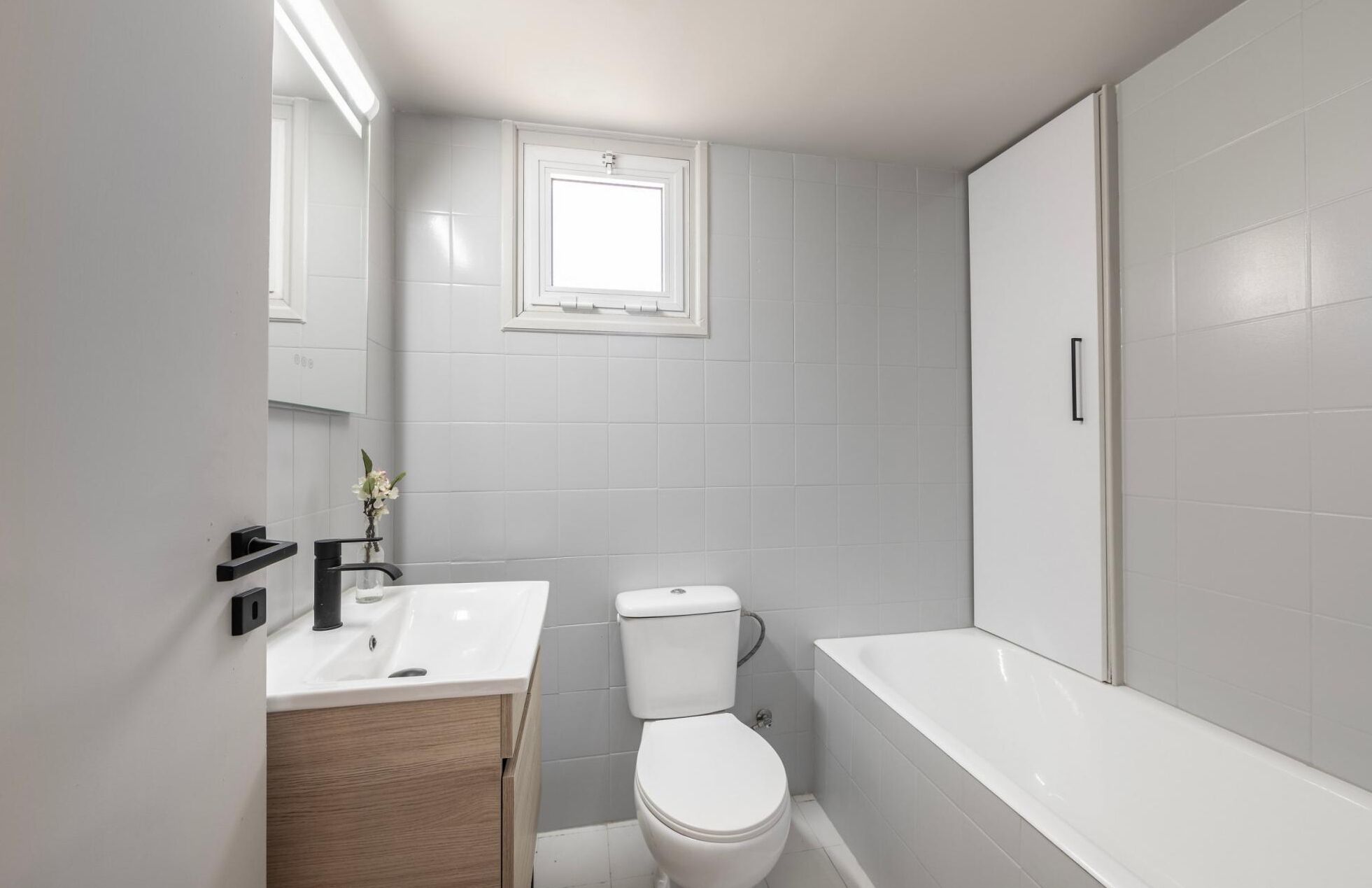A modern bathroom with a toilet, sink, and bathtub.