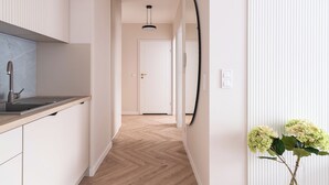 A modern kitchen with a wooden countertop and a large mirror. - RentPlanet - Nowa Manufaktura (Wroclaw)