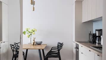 Deluxe appartement | Privékitchenette | Een koelkast, een kookplaat, kookgerei, borden en bestek