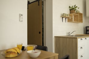 A modern kitchen with a wooden countertop, a sink, and a small shelf with a plant.