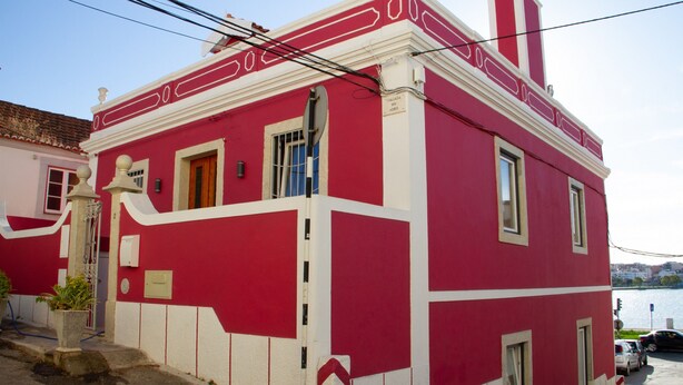 Un edificio rojo y blanco de estilo arquitectónico tradicional, con una chimenea destacada, una puerta y ventanas.