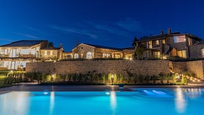 Un edificio grande de piedra con varias habitaciones y una piscina.