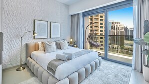 Une chambre moderne dotée d’un grand lit, d’un fauteuil suspendu et offrant une vue sur la ville grâce à de grandes fenêtres du sol au plafond.