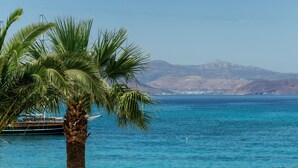 A coastal scene with a clear view of the sea and a mountain in the background. - Ostrako Beachside Suites (Naxos)